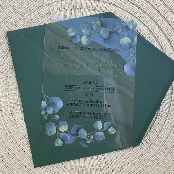 Cette photo représente un faire part de mariage imprimé sur plexiglass. Le design est tourné autour de la plante eucalyptus. Il est accompagné de son enveloppe assortie.